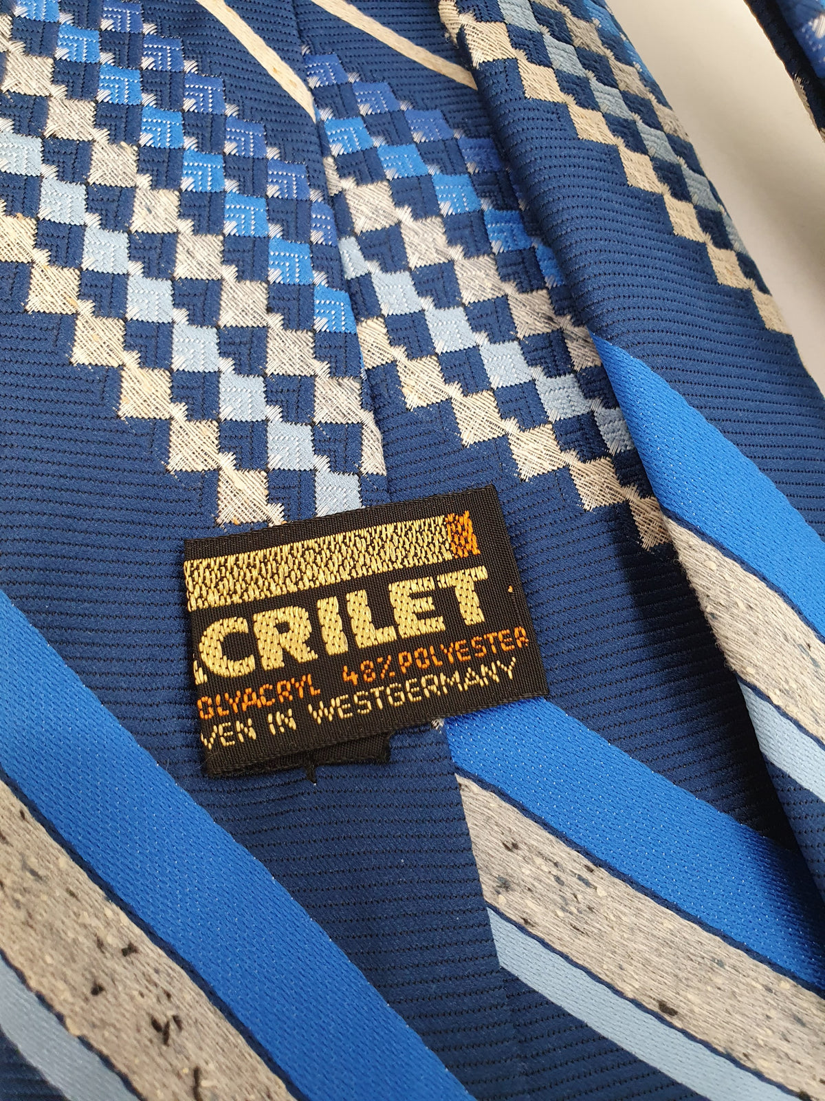 Acrilet retrokravatti, logo
