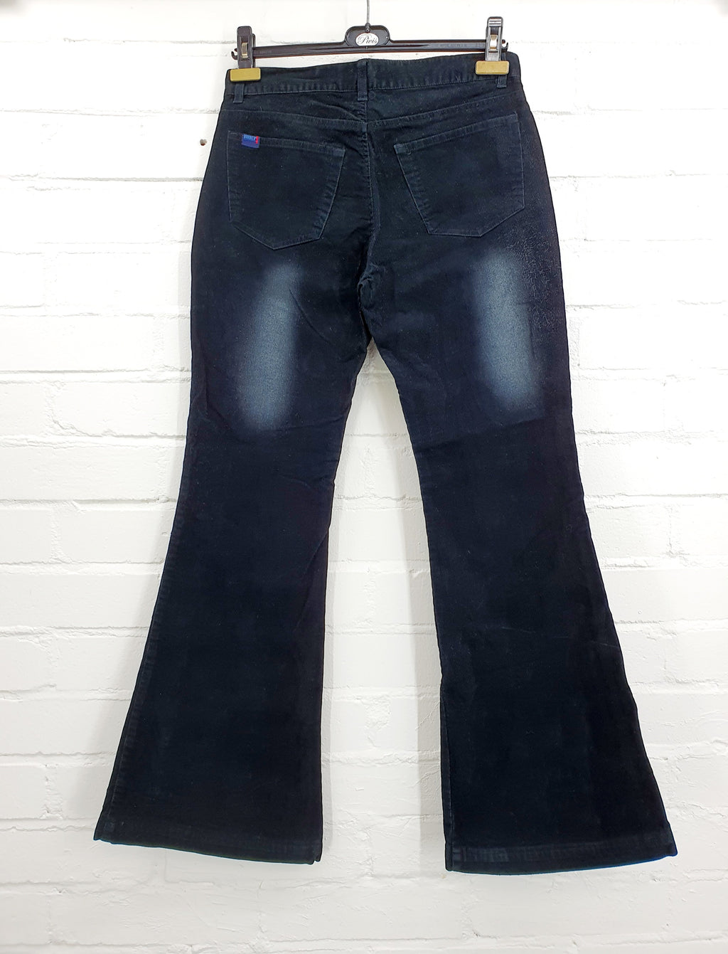 Mustat Y2K samettihousut flare/bootcut-lahkeella, kulutetun näköinen kuosi lahkeissa, kuva takaa